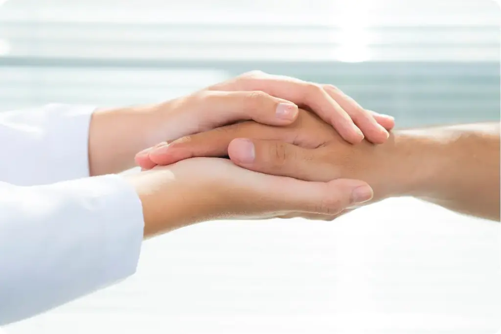 Therapist holding a patient’s hands during partial hospitalization program treatment