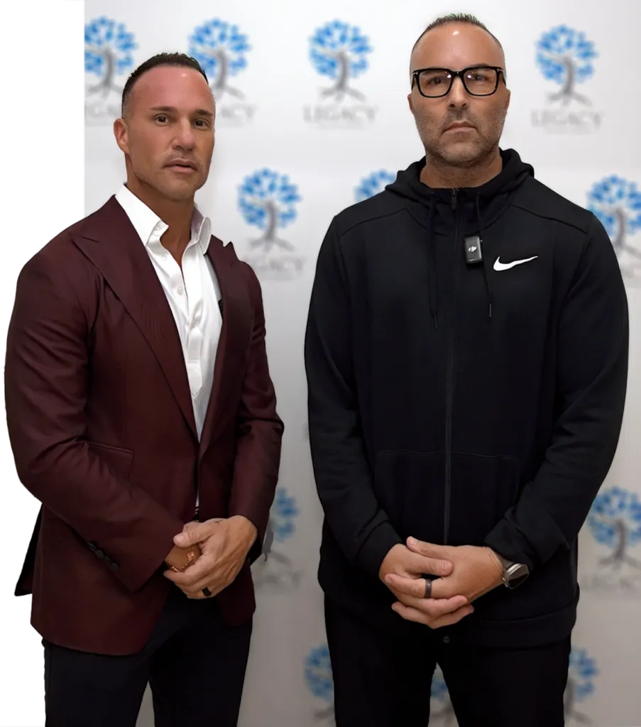 Two men in formal attire posing.